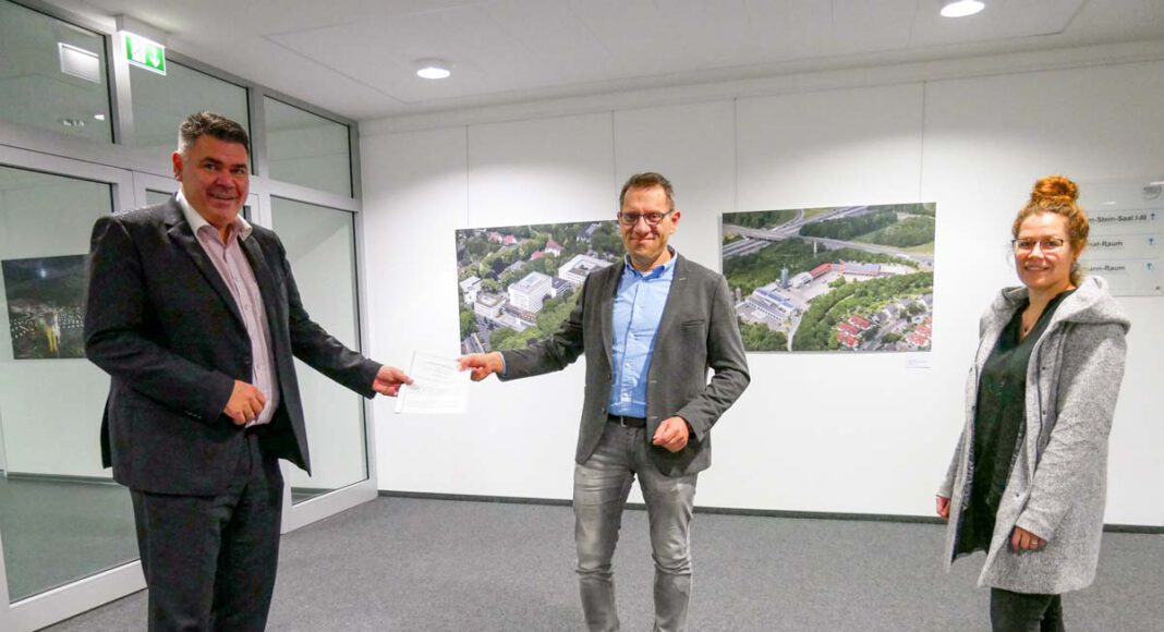 Landrat Mario Löhr (l.) mit dem Vertrag mit der Kreisstadt Unna über die Erstellung eines Mietspiegels, Fachbereichsleiter Martin Oschinski (M.) und Bianca Maertin von der Geschäftsstelle des Gutachterausschusses (r.). Foto: Max Rolke - Kreis Unna