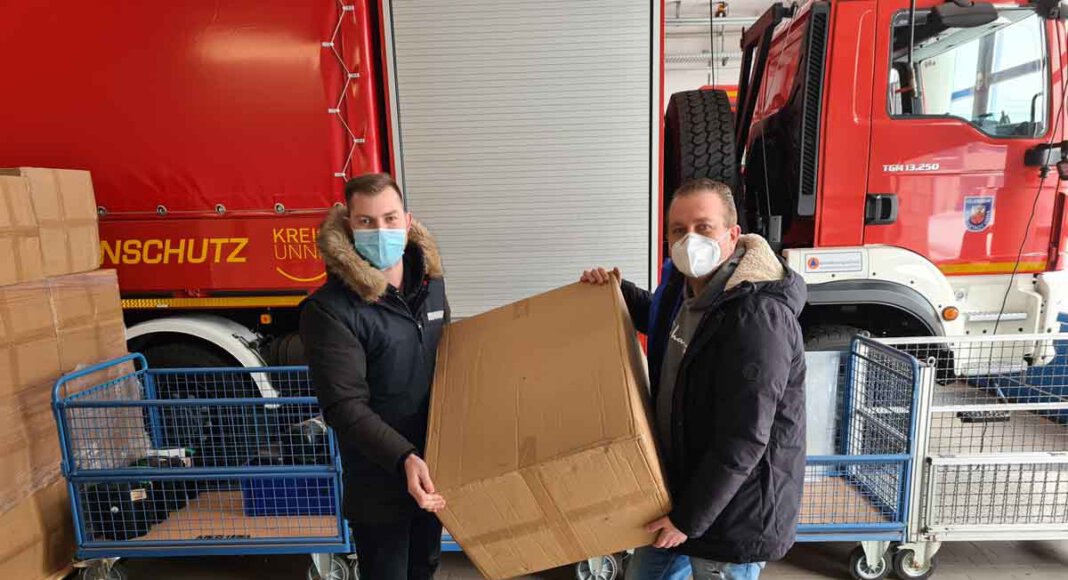 Rudolf Meisner, im Auftrag des Ordnungsamts der Stadt Werne, und Kai Proske vom Bevölkerungsschutz des Kreises beim Verladen der Masken für die Stadt Werne. Foto: Patrick Isken