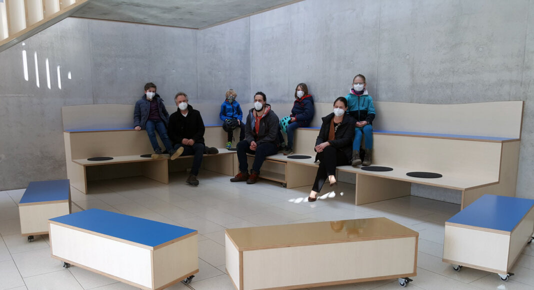 Der Vorstand des Wiehagenschule-Fördervereins (unten von links) Heiko Lexius, Till Garvert und Barbara Lindenblatt präsentieren mit Laurin (oben v.l.), Theo, Jona und Greta die vielseitig einsetzbare Holztribüne im Foyer der Grundschule. Foto: Wagner