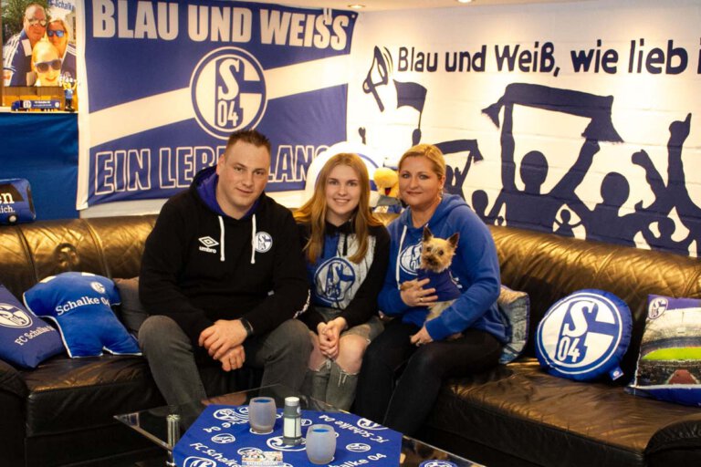 Im Fan-Keller der Domnowskis ist alles in blau-weiß gehalten. Schalke ist ihre Liebe: Andreas, Cindy und Bogda Domnowski mit Hund Chucky. Wenn sie an Rudi Assauer denken, fangen sie an zu lächeln. Erzählen sie über die Gegenwart, wird die Tonlage ernster. Foto: Isabel Schütte