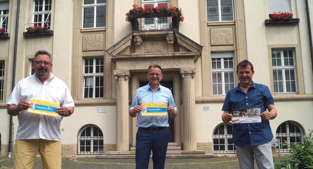 Die neue Gutscheinaktion startet mit dem Vorverkauf am 21. Juni. Bürgermeister Thomas Orlowski (M.), Norbert Zolda (r./Stadtmarketing) und Thomas Kaim von der Werbegemeinschaft werben für die Aktion, die Selmer Händlern und Gastronomen zu Gute kommt. Foto: M. Woesmann / Stadt Selm