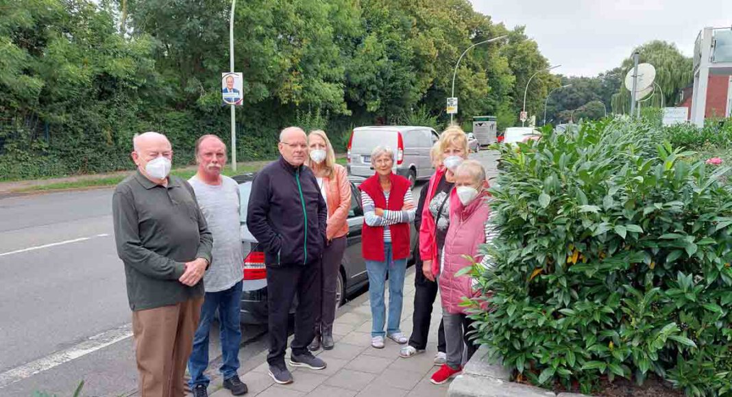 Demonstrativ stellen sich Anwohner/innen der Hausnummern 11 und 13 auf den Geweg an der Lünener Straße. Hier kam es durch rücksichtsloses Verhalten einer E-Bike-Fahrerin zu einem schweren Zusammenstoß mit einer Fußgängerin. Die Mauer mit Bepflanzung sorgt für zusätzliche Gefahr. Foto: Wagner