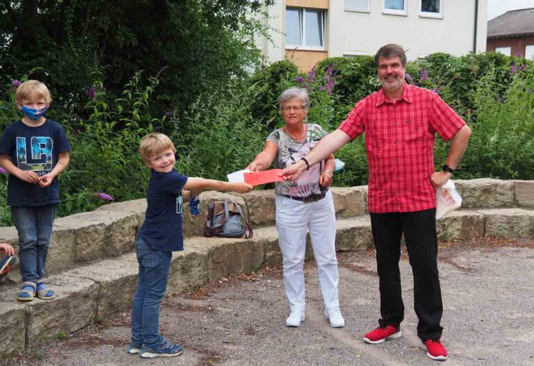 Marita Funhoff und Michael Thews (SPD) förderten das Ferienprogramm an den drei Werner Grundschulen mit einer Spende. Auf dem Foto überraschen sie OGS-Kinder an der Wiehagenschule. Foto: SPD