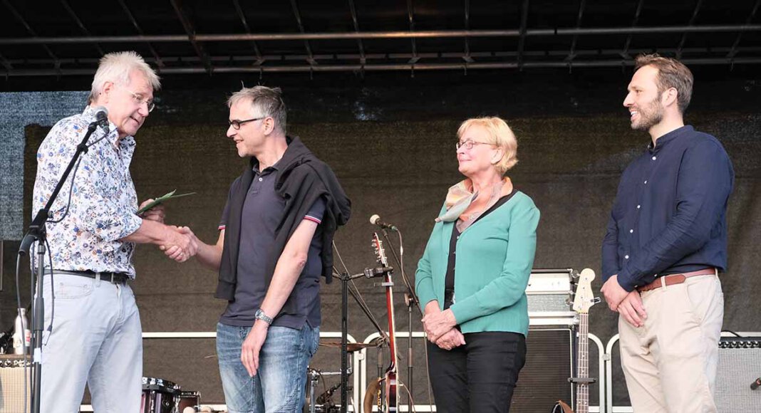 Spendenübergabe auf der Bühne (von links): Klaus Schlüter (Grüne Werne), Roland Sperlich (FlözK), Hiltrud Mannig (Grüne Werne) und Martin Kesztyüs (Kandidat der Grünen Werne zur Bundestagswahl). Foto: Bündnis 90 / Die Grünen