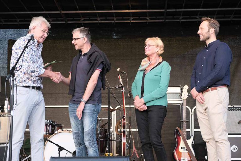 Spendenübergabe auf der Bühne (von links): Klaus Schlüter (Grüne Werne), Roland Sperlich (FlözK), Hiltrud Mannig (Grüne Werne) und Martin Kesztyüs (Kandidat der Grünen Werne zur Bundestagswahl). Foto: Bündnis 90 / Die Grünen