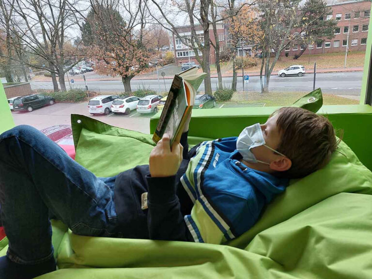 Erik machte es sich beim Tag der offenen Tür der Marga-Spiegel-Schule gleich in der Bibliothek gemütlich, genoss Buch und Ausblick. Foto: Wagner