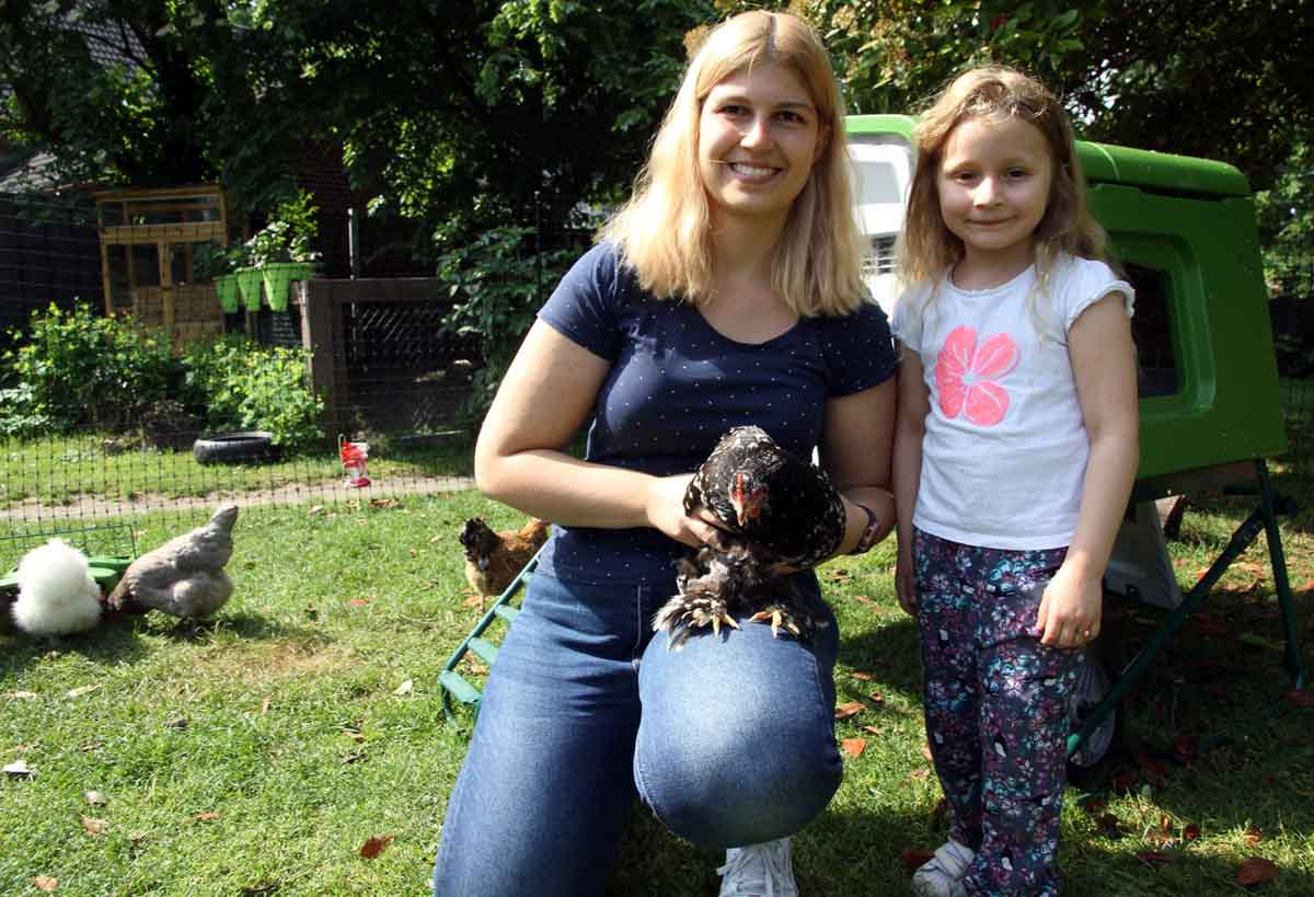Erzieherin Sophia Verse und Mila kümmerten sich mit den anderen Kita-Kindern um die sieben Hühner. Foto: Wagner