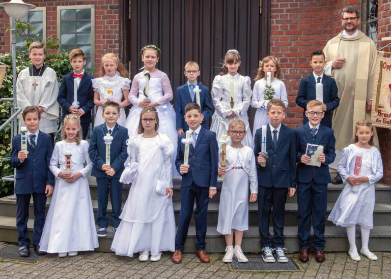 Die Erstkommunionkinder mit Pfarrer Karl Heinz Hense vor St. Sophia in Stockum. Foto: Privat