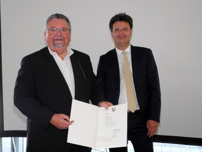 Helmut Gravert (li.) nahm seine Entlassungsurkunde aus dem Schuldienst vom Dezernenten der Bezirksregierung, Dieter Freialdenhoven, entgegen. Foto: Klaus Brüggemann