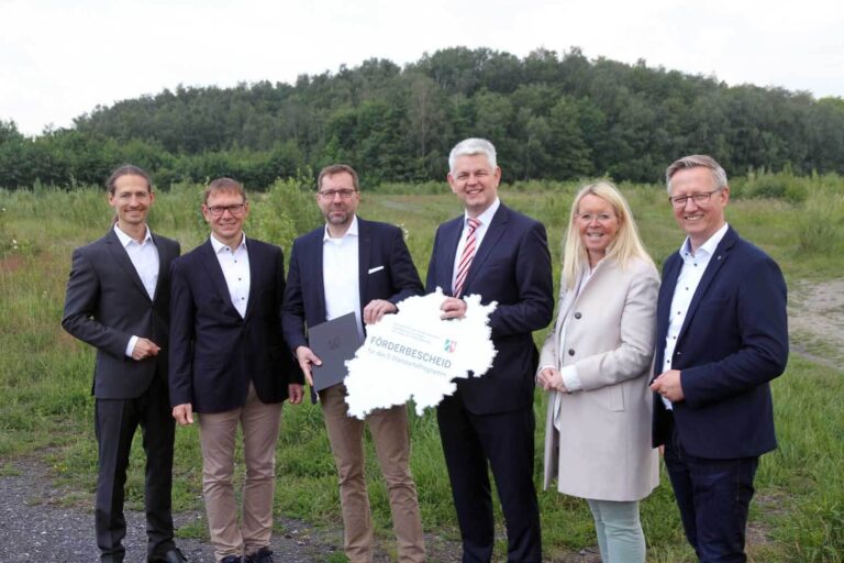 Staatssekretär Christoph Dammermann (4. von links) überreichte den Förderbescheid an Projektentwickler Dr. Michael Detering (3. von links), im Beisein von Sascha Dorday, Wirtschaftsförderer für den Kreis Unna, Bürgermeister Lothar Christ, Uta Leisentritt (Vorsitzende Ausschuss für Stadtentwicklung) und Wernes Wirtschaftsförderer Matthias Stiller (von links). Foto: Wagner