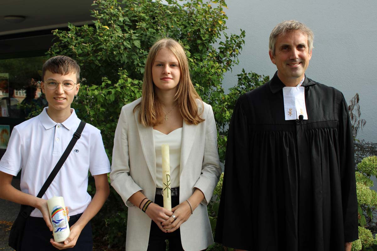Leni Wortmann und Mathis Schneider, hier mit Pfarrer Alexander Meese, sind die ersten Konfirmanden 2022. Foto: Ev. Kirchengemeinde