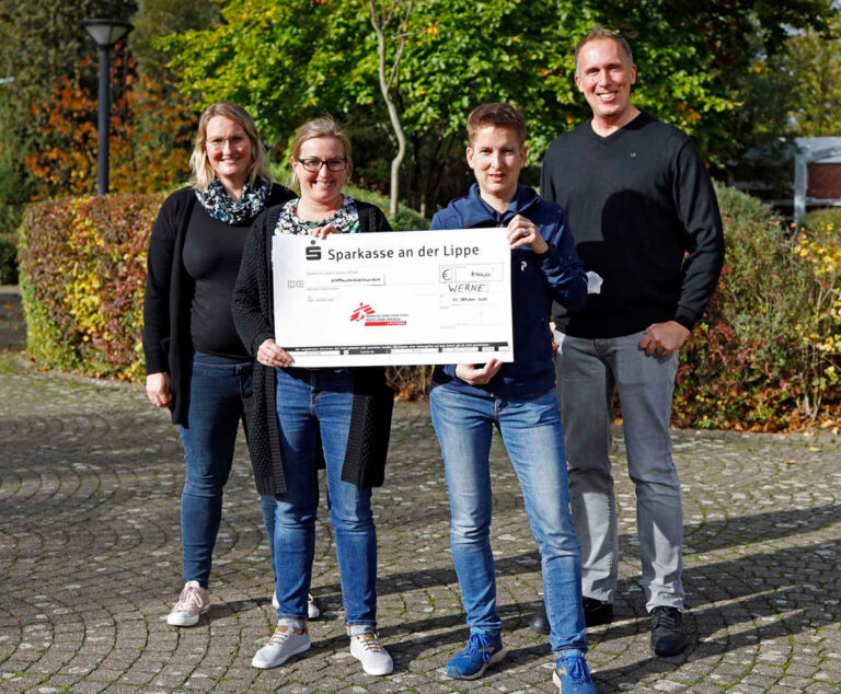 Die Organisatorinnen des Spendenlaufs am Gymnasium St. Christophorus präsentieren mit Schulleiter Thorsten Schröer den Spendenscheck für "Ärzte ohne Grenzen". Foto: privat
