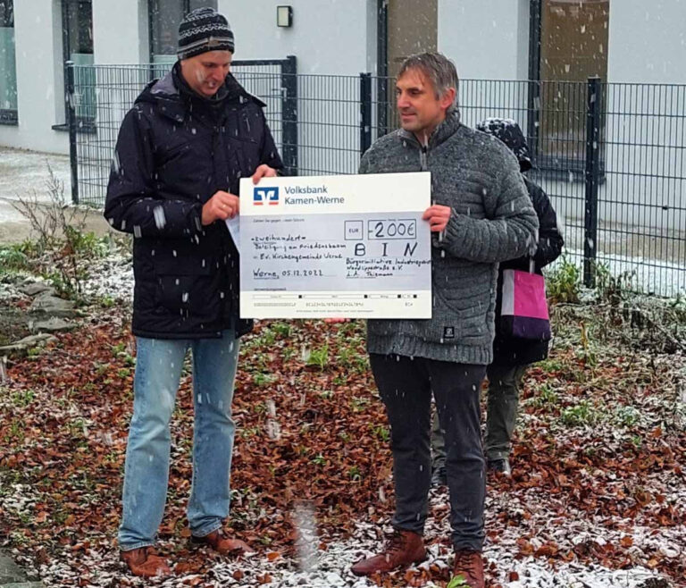 Werner Thiemann (links) überreichte im Namen der BIN eine Spende an Pfarrer Alexander Meese für das ukrainische Frauen-Café im Bonhoeffer-Zentrum. Auch an der Pflanzung eines Friedensbaumes beteiligte sich die Bürgerinitiative. Foto: Wagner