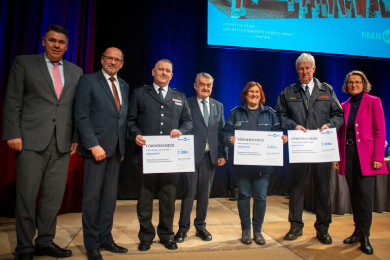 Landrat Mario Löhr (l.), Vizepräsident des Landtags Rainer Schmeltzer, NRW-Innenminister Herbert Reul (M.) und Heimatministerin Ina Scharrenbach (r.) mit den glücklichen Gewinnern der drei Förderchecks. Foto: Kreis Unna - Alexander Heine