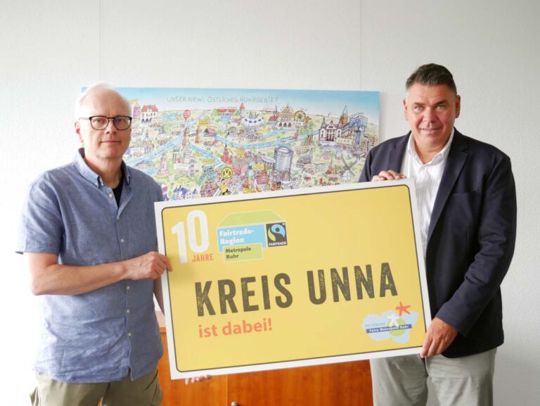 Matthias Tresp (links) vom Fachbereich Mobilität, Natur und Umwelt und Landrat Mario Löhr: Das Ruhrgebiet ist seit zehn Jahren Fairtrade-Region, der Kreis Unna ist seit 2020 mit dabei. Mit dem symbolischen Ortseingangsschild zeigt der Kreis Unna seine Zugehörigkeit zur fairen Metropolregion. Foto: Kreis Unna