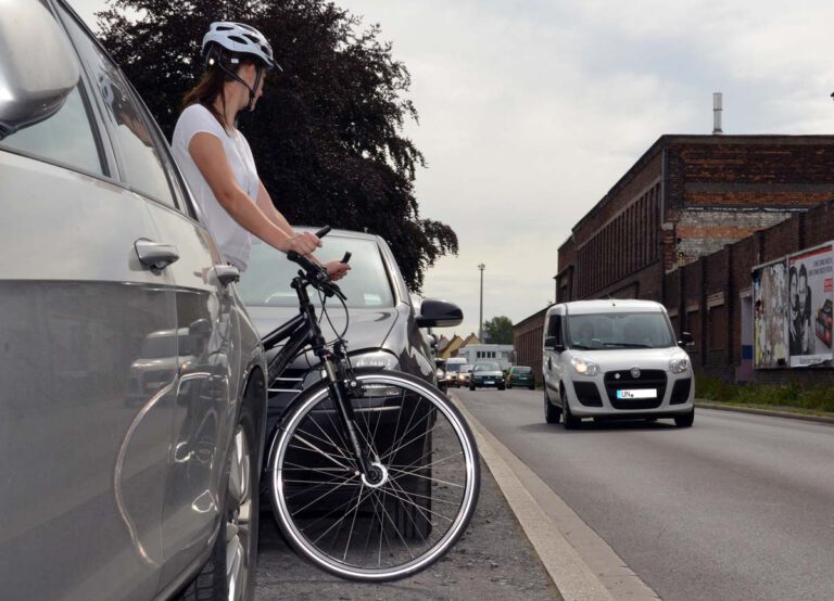Wer als Radfahrer die Straße überqueren will, sollte sich nicht zwischen zwei geparkten Autos positionieren. So ist man für heranfahrende Autos nur sehr spät zu sehen. Wer eine Straße queren möchte, sollte einen Bereich wählen, der für alle Verkehrsteilnehmer gut einsehbar ist. Foto: Kreis Unna