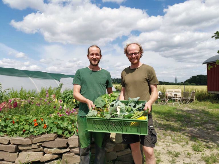 Laurin Liekenbrock (rechts) und Mitarbeiter Andreas zeigen saisonale Ernteanteile aus der letzten Woche. Foto: Johanna Glowacki