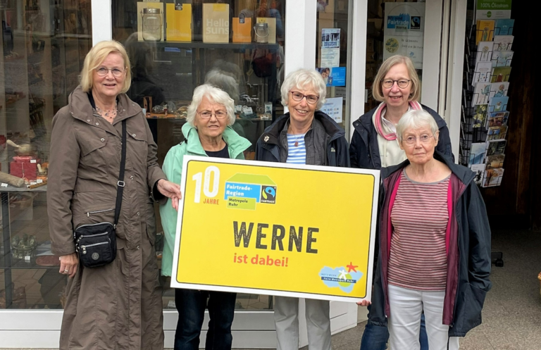 Vor dem Eine-Welt-Laden wird das neue Ortsschild vorgezeigt: Werne gehört zur Fairen Metropole Ruhr. Foto: Viefhues