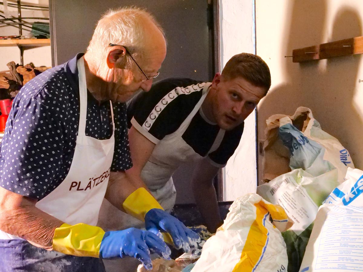 Alle Hände voll zu tun: Willi Jasper und sein Enkel Tristan Essiger stecken bis zu den Ellenbogen im Kartoffelteig. Foto: Schwarze
