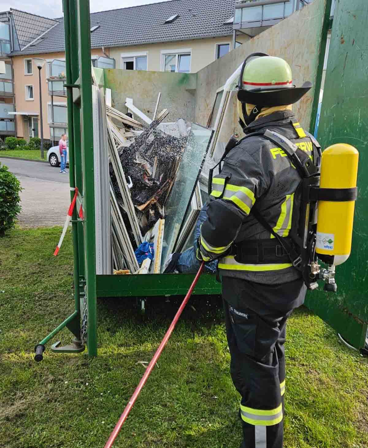 Der zuvor brennende Container wurde noch mit dem Gartenschlauch gekühlt. Foto: FFW