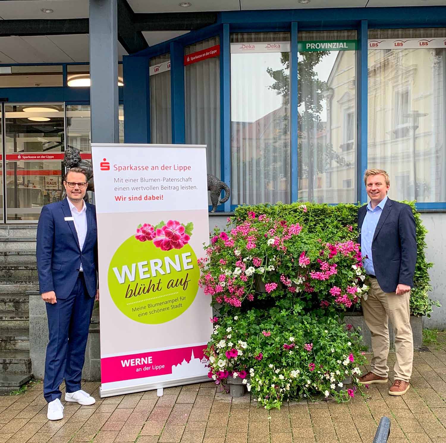 Andree Heimann, Sparkasse an der Lippe, und Lars Werkmeister, Werne Marketing GmbH, präsentieren die neue Blumensäule vor dem Haupteingang der Sparkasse. Foto: privat