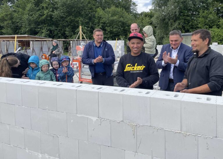 Bei der Grundsteinlegung für eine neue Kita an der Oberstraße in Südkirchen mauerte Bürgermeister Dietmar Bergmann (2.v.r.) unter den neugierigen Blicken einiger Kita-Kinder und von Axel Lorenz vom Investor Gebrüder Lorenz (M.) eine Zeitkapsel ein. Foto: Gemeinde Nordkirchen/Hauck