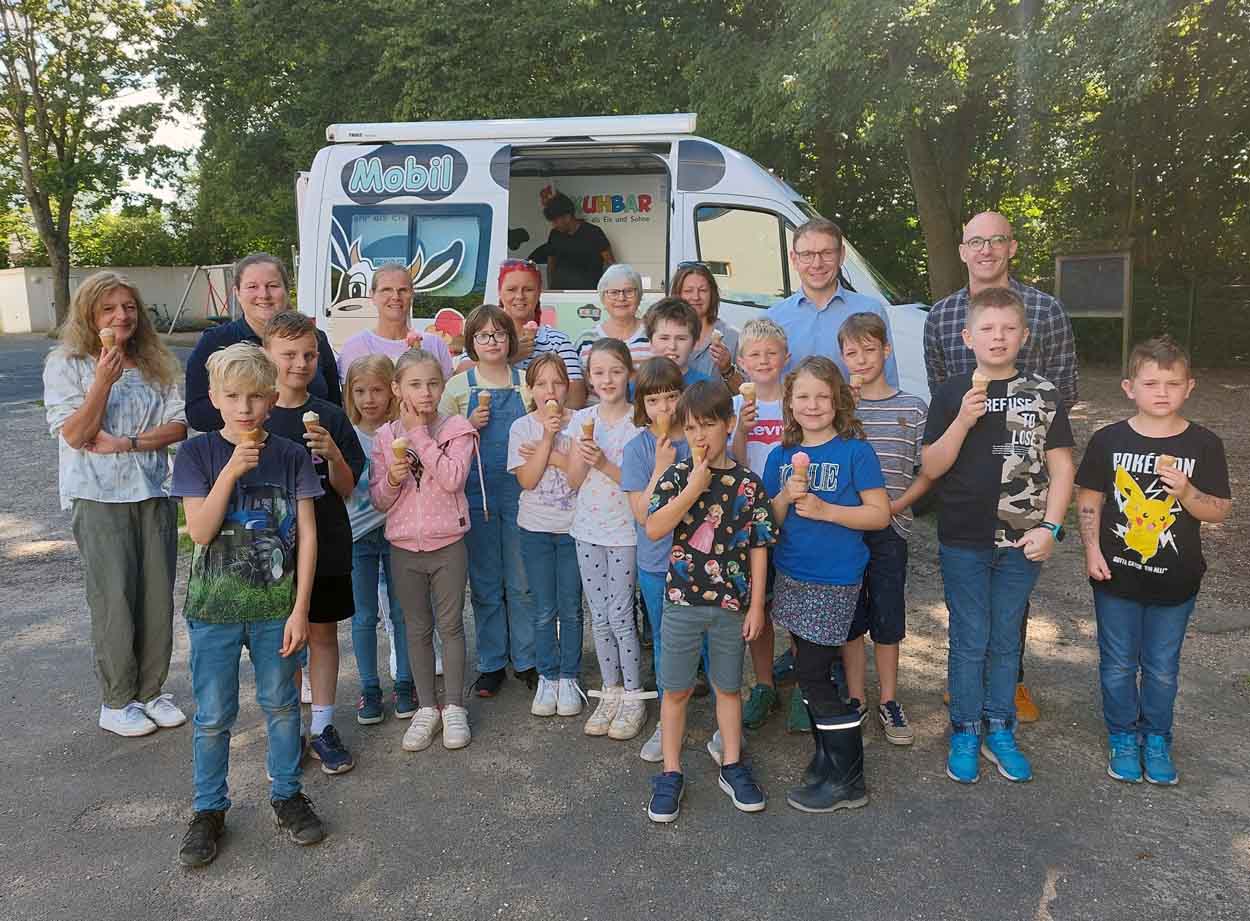 Die Kinder der Kardinal-von-Galen-Schule in Stockum freuen sich hier über das Gratis-Eis, das Bürgermeister Lothar Christ und Jugendpfleger Jens Viandante traditionell zum Auftakt des OGS-Ferienprogramms mitgebracht hatten. Foto: Wagner
