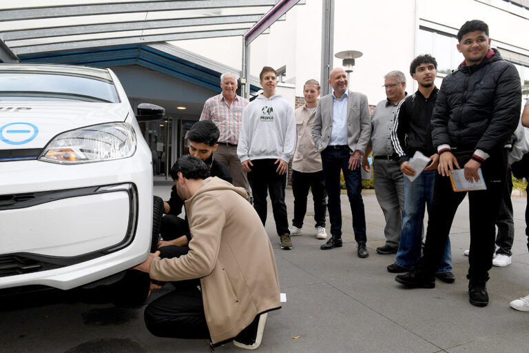 Ein „Beruf zum Anfassen“ bot das Lüner Autohaus Trompeter bei der Jobmesse des Berufskollegs Werne. Beim Radwechsel auf Zeit stellten Freiwillige ihre Geschicklichkeit unter Beweis. Über das Interesse freuten sich der stellvertretende Schulleiter Markus Werner (4.v.l.) sowie „Übergangslotse“ Jonathan Schuster (3.v.l.), Dirk Stephanblome, Bereichsleiter für die Duale Berufsausbildung (l.), und Werkstattlehrer Michael Adams (3.v.l.). Foto: MSW