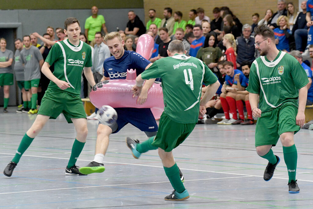 Mit dem sperrigen Flamingo-Schwimmreifen als Handicap versucht sich Nico Holtmann gegen drei Spieler des FC Schützen durchzusetzen. Foto: MSW