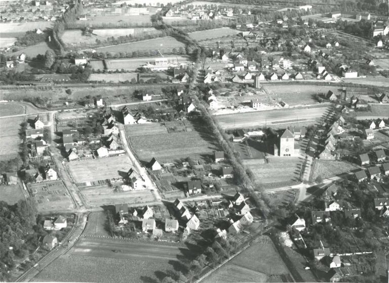 Das alte Luftbild mit Blick nach Osten stammt aus dem Jahr 1961. Es zeigt den Werner Westen mit der Pfarrkirche Maria Frieden im Mittelpunkt. Von links nach rechts kann man die Straßen Münsterfort, Haferfeld/Kolpingstraße, Ovelgönne, Windmühlenberg erkennen. Der quer verlaufende und noch nicht ausgebaute Goetheweg mündet am sogenannten „Dreieck“ in die Selmer Straße. Im Hintergrund erkennt man gut die Bahnline mit dem Werner Bahnhof und dem ehemaligen Wasserturm an der Overbergstraße. Foto: Stadtmuseum Werne