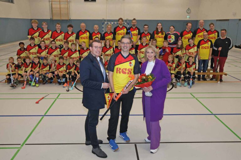 Bei der Trikotübergabe (v.l.n.r.): Alexander Rimmer, André Wagner und Adelheid Hauschopp-Francke. Im Hintergrund freuen sich viele Vereinsmitglieder in ihren neuen Trikots. Foto: Volkmer