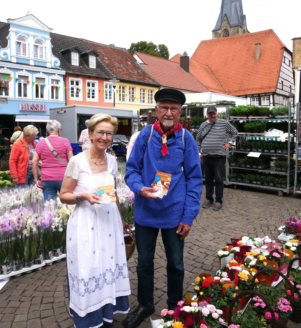 Die Info-Flyer für das große Jubiläumsfest des Heimatvereins 26. Juli brachten am Markttag Kiepenkerl Heinrich Wittemeyer und Barbara Schaewitz in zünftig-münsterländischer Tracht unter die Leute. Foto: Gaby Brüggemann