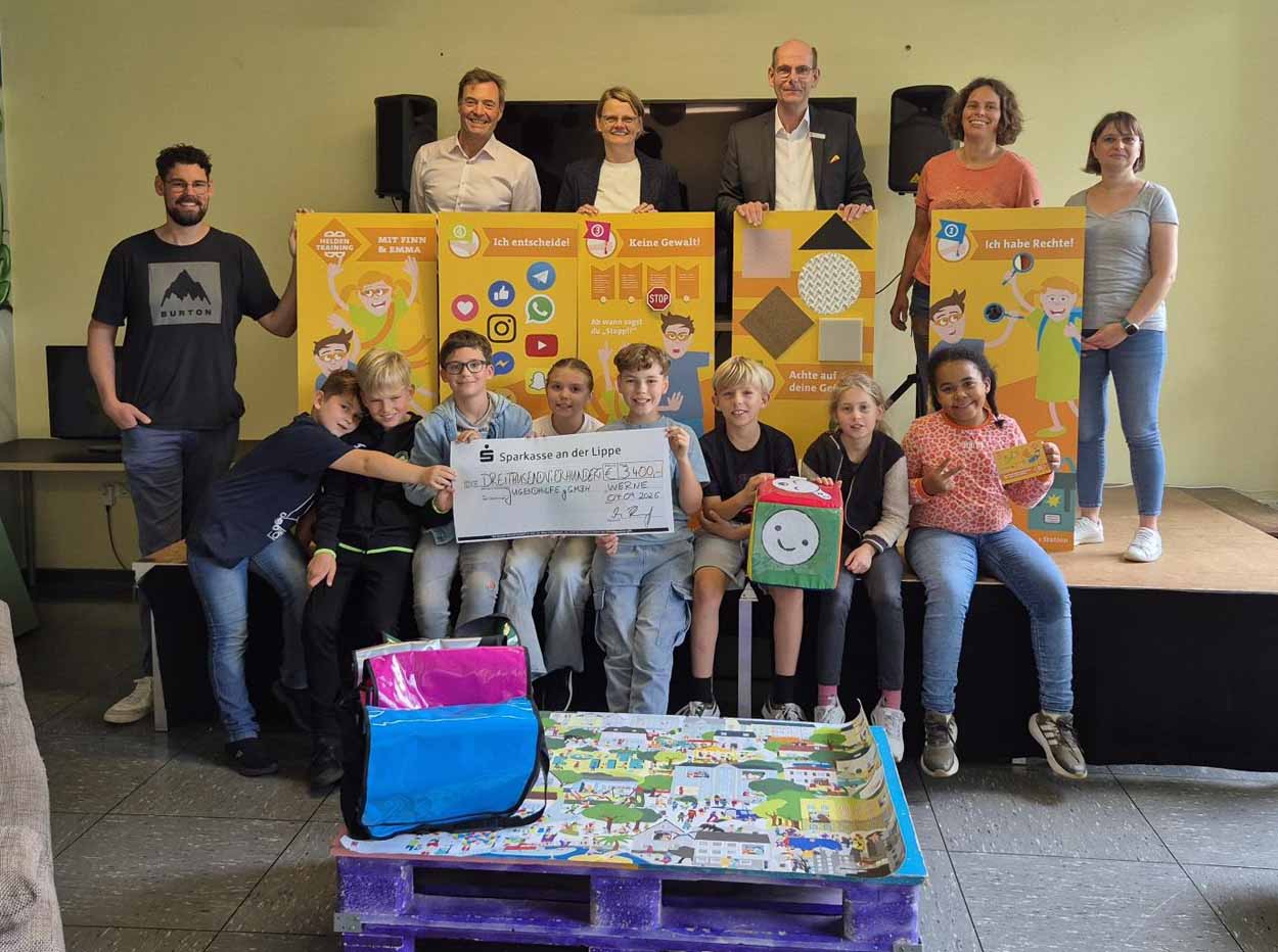 Martin Abdinghoff von der Sparkasse überreichte den symbolischen Scheck an die Geschäftsführung der Jugendhilfe und im Beisein vieler Kinder. Foto: privat