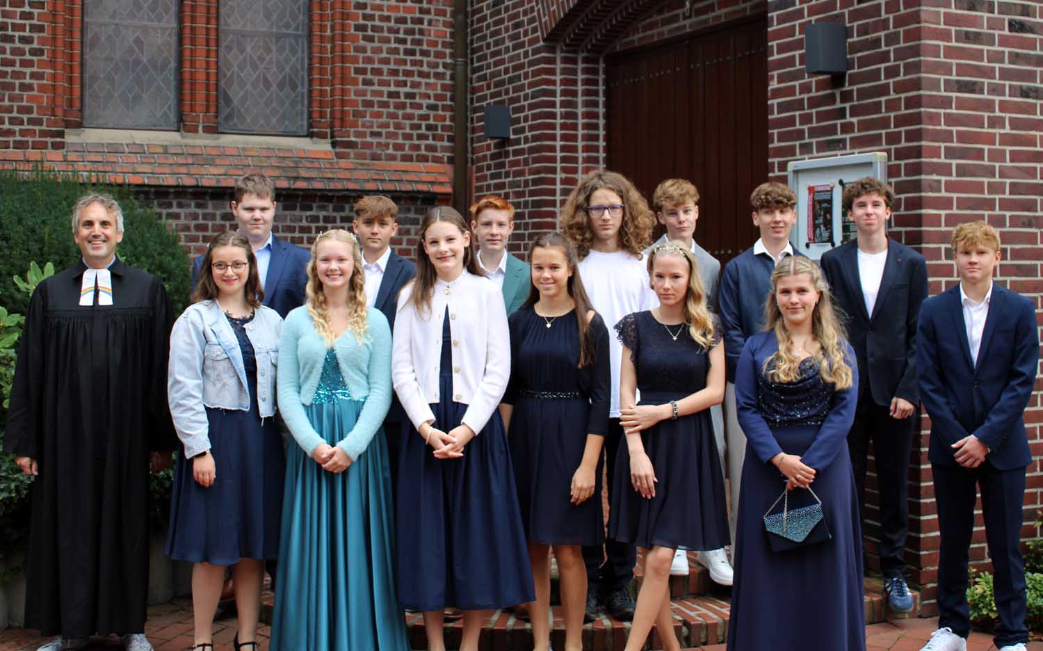 Pfarrer Alexander Meese mit (von links) Sofie Schick, Jeremy Friedrich, Lia Bilitz, Tom Wonsak, Johanna Altfeld, Hernri Karb, Amelie Schuze-Beckinghausen, Jakob Wiesmann, Finja Kerkhoff, Emil Schmitz, Luca Weber, Sarah Große Brochtrup, Laurin Lexius und Luka Kuhn vor der Martin-Luther-Kirche. Fotos: Ev. Kirche