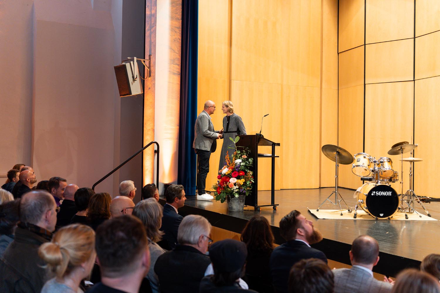 Marion Freitag, Leiterin der Stabsstelle Kultur und Tourismus, begrüßt David Klapheck, den Sohn des Künstlers Konrad Klapheck, auf der Bühne des Theaters im Museum Schloss Cappenberg. Foto: Image Kollektiv Carmen_Koerner