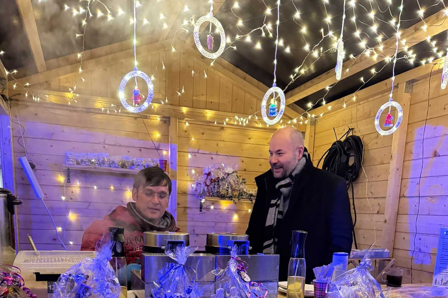 Erhan Dogan begrüßte bei einem Vor-Ort-Besuch des Weihnachtsmarktstandes, hier zusammen mit Marius Gellert, die Bemühungen des noch in der Gründungsphase befindlichen Vererins „Rollstuhlgerecht in Stadt Werne“. Foto: Verein