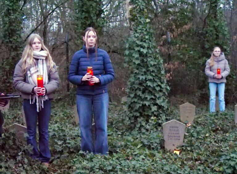 Sozusagen als lebendige Mahnmale postierten sich die Schülerinnen neben den Grabsteinen. Foto: Schwarze