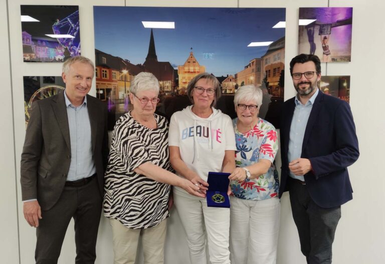 Westenergie-Kommunalmanager Dirk Wißel (l.) übergibt gemeinsam mit Bürgermeister Lars Hübchen (r.) den LokalStars-Award an Ingrid Budde, Marlies Förster und Angelika Böcker (v.l.n.r) von der Initiative „Nähen – Gutes tun“. Foto: Stadt Werne / Niklas Wilde